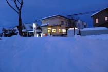 夕暮れ時、雪の中にあたたかな光がこぼれる。